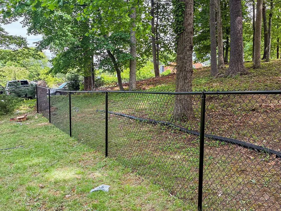 Black vinyl-coated chain link fence installed by Star City Fence Co